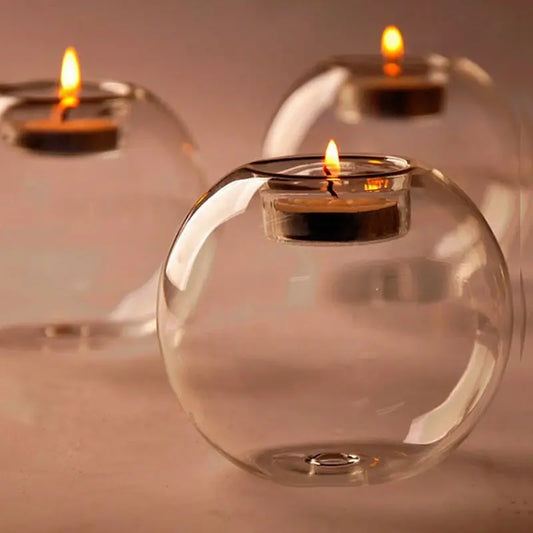 Crystal Orb Candle Holder Photo of three transparent orb tea light candle holders with candles lit