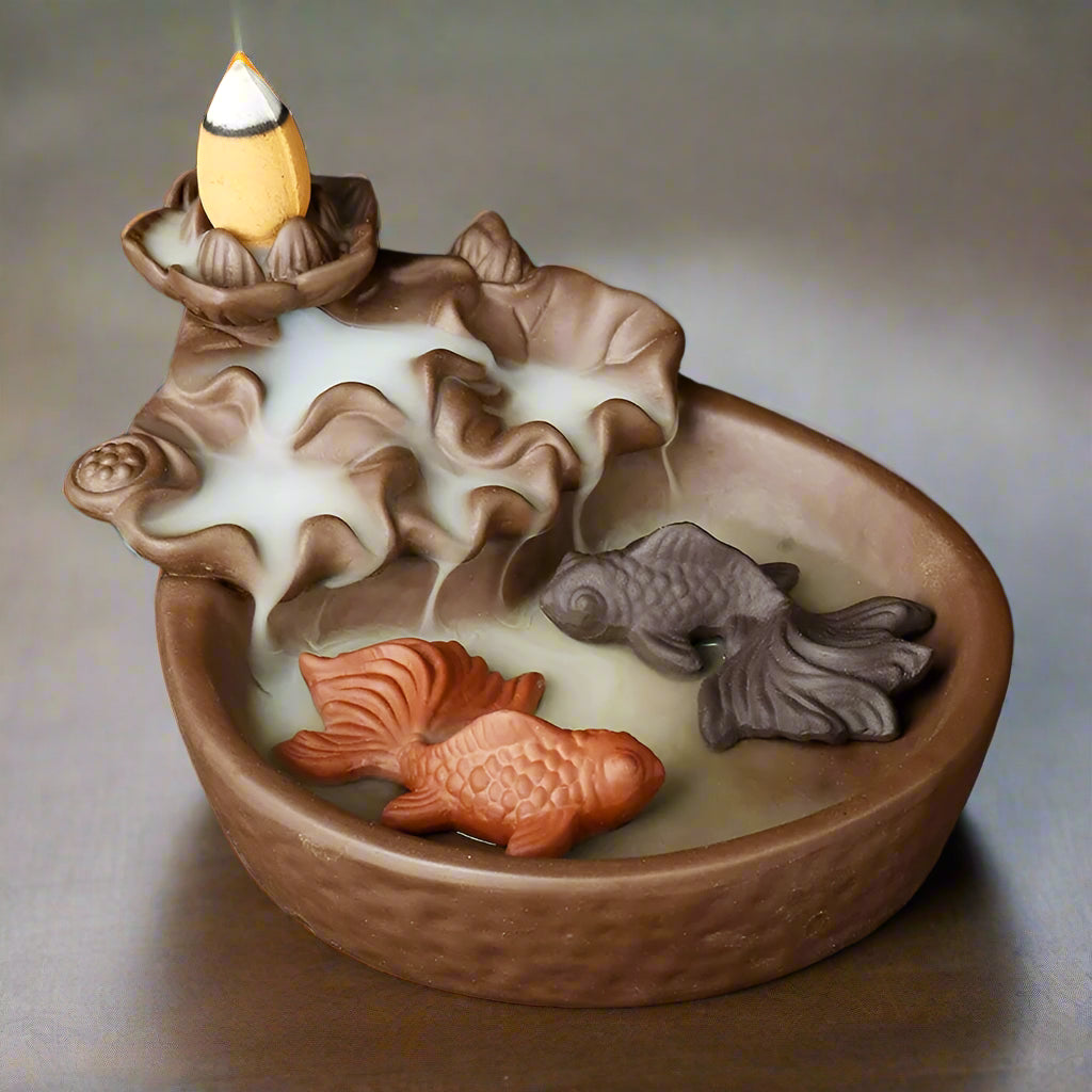 Koi Pond Backflow Incense Burner, on a wooden table top with gentle lighting. wellness by heart.